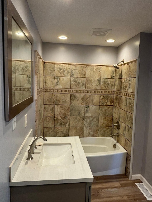 bathroom featuring vanity, tiled shower / bath combo, and hardwood / wood-style flooring