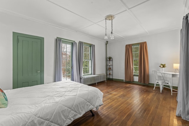 bedroom with dark hardwood / wood-style flooring, crown molding, and radiator