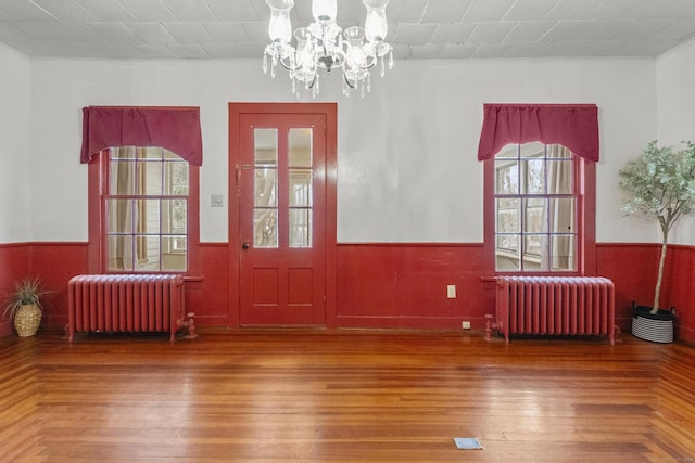 doorway to outside with radiator heating unit and crown molding