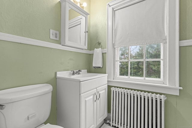 bathroom featuring vanity, toilet, and radiator