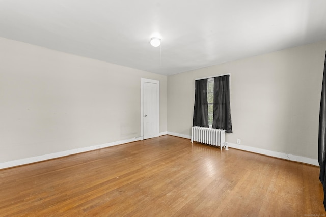 empty room featuring hardwood / wood-style flooring and radiator