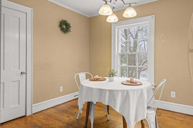 dining area with wood-type flooring and ornamental molding