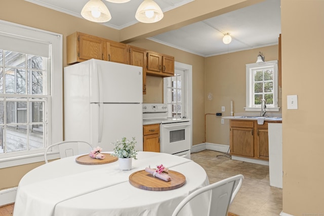 kitchen with plenty of natural light, pendant lighting, white appliances, and sink