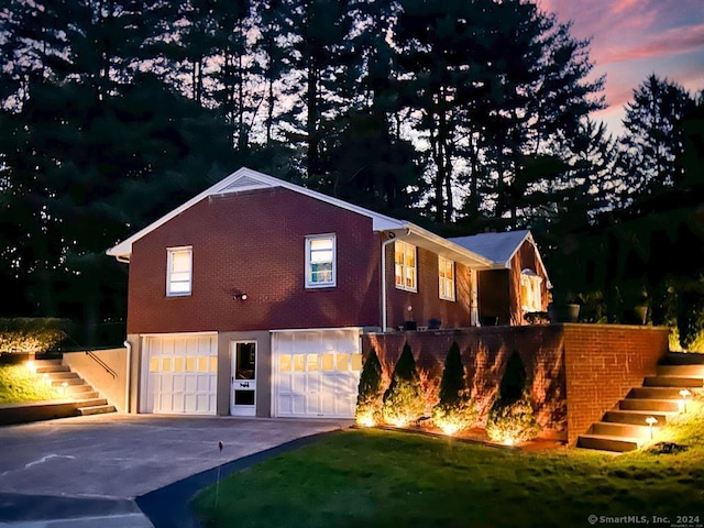 back house at dusk with a garage