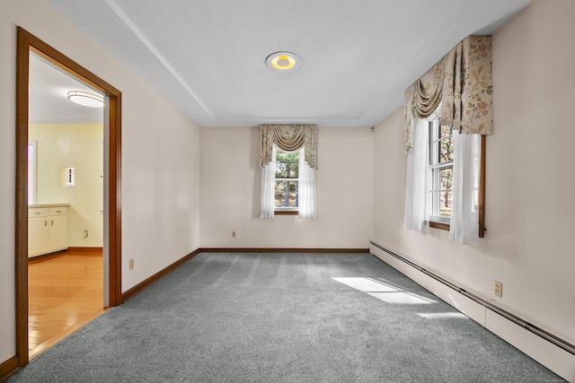 carpeted spare room with a baseboard radiator and a wealth of natural light