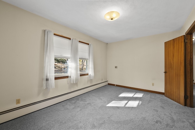 carpeted spare room featuring baseboard heating