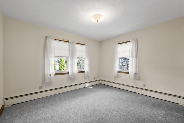 carpeted spare room featuring a baseboard heating unit