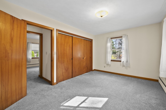 bedroom with carpet flooring, a baseboard heating unit, and multiple windows