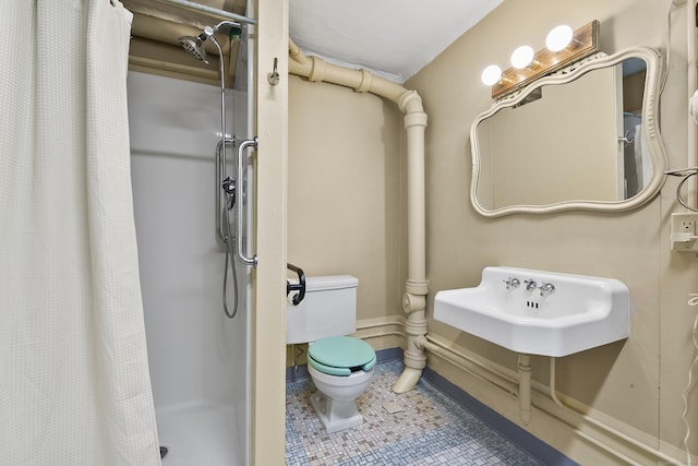 bathroom with curtained shower, sink, tile patterned flooring, and toilet