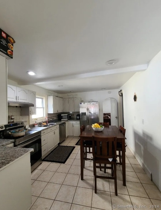 kitchen with white cabinets, sink, appliances with stainless steel finishes, tasteful backsplash, and light tile patterned flooring