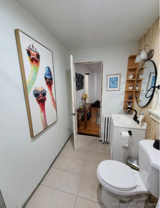 bathroom featuring toilet, radiator heating unit, vanity, and tile patterned flooring