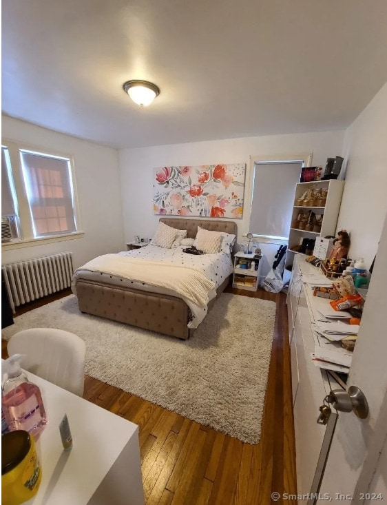 bedroom featuring hardwood / wood-style floors and radiator