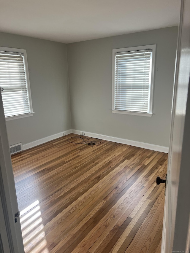 empty room featuring hardwood / wood-style floors and plenty of natural light