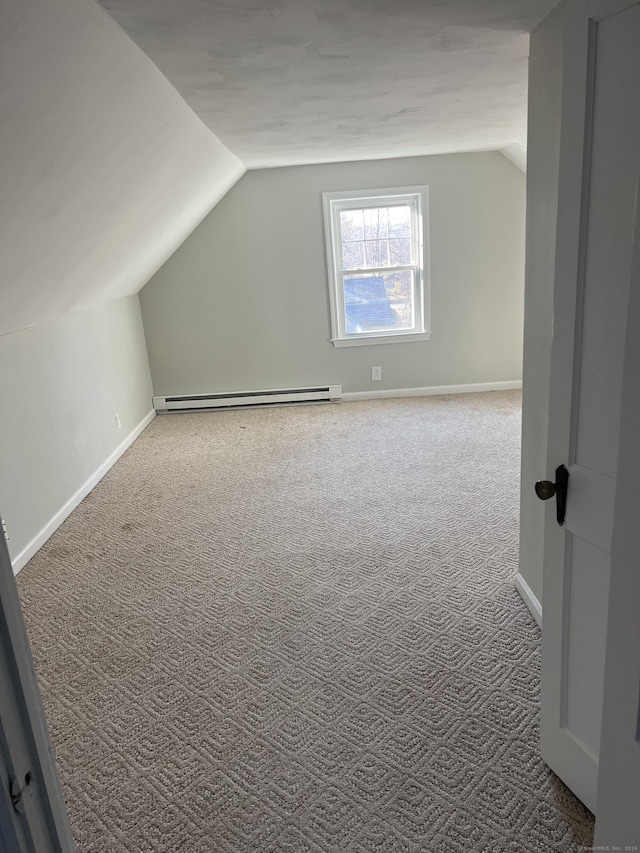 additional living space featuring carpet floors, a baseboard radiator, and vaulted ceiling