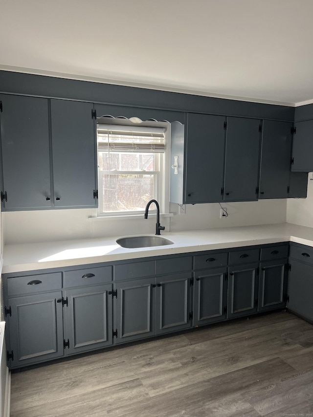 kitchen featuring gray cabinetry, sink, and light wood-type flooring