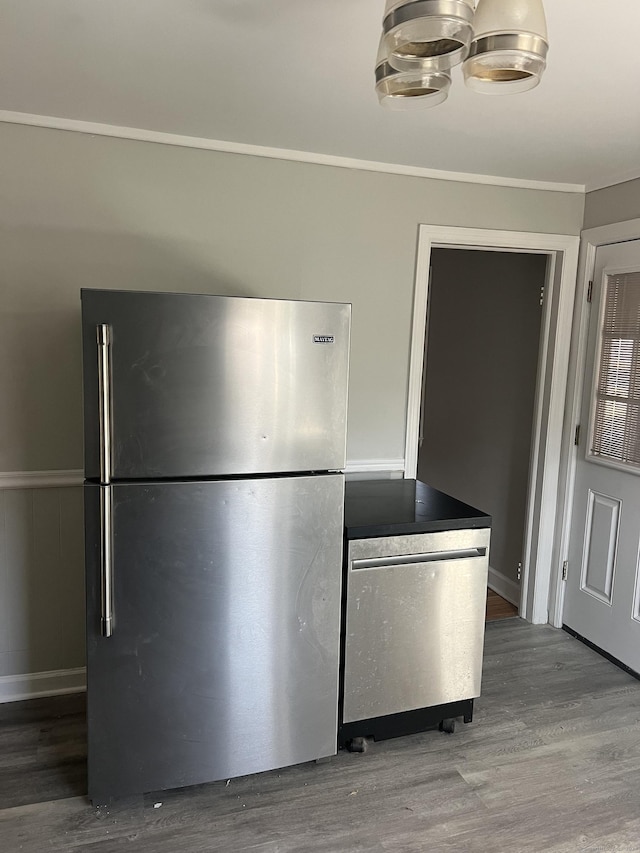 kitchen with hardwood / wood-style floors, a notable chandelier, and stainless steel appliances