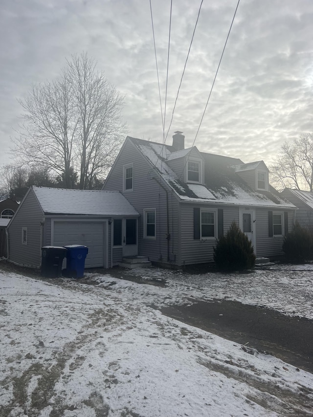 snow covered property with a garage