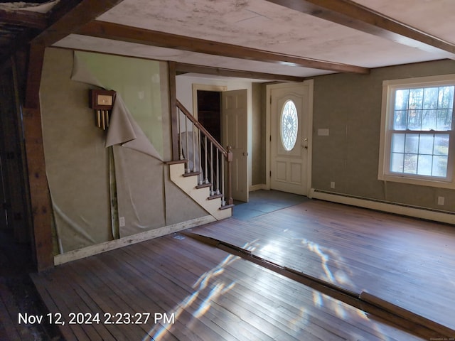 entryway with beam ceiling, light hardwood / wood-style floors, and a baseboard heating unit