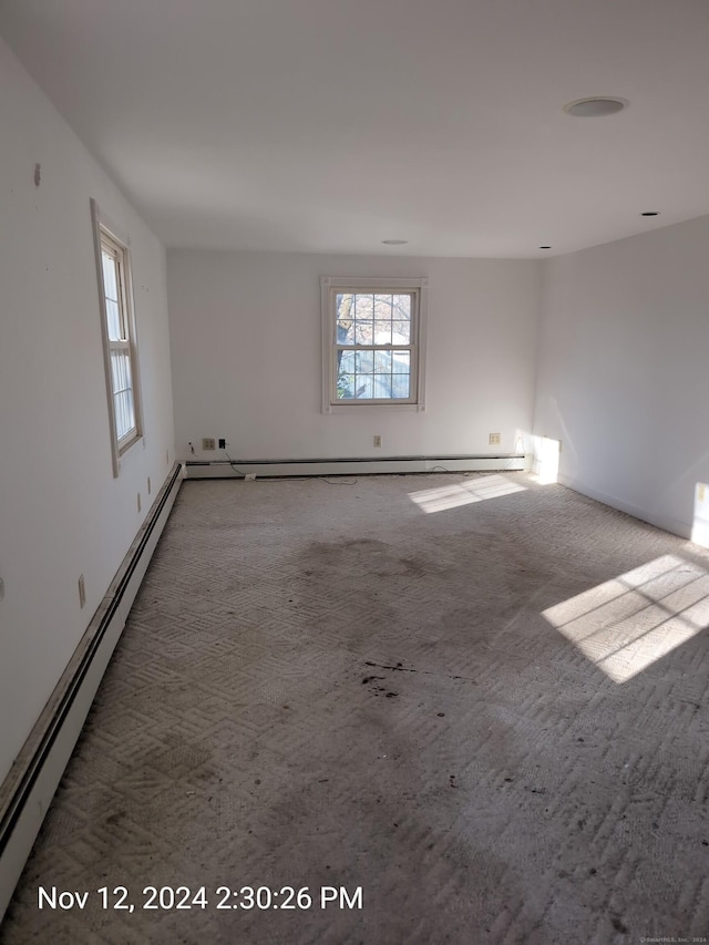 unfurnished room featuring carpet floors and a baseboard radiator