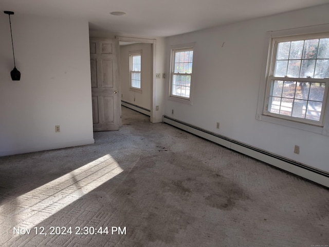 interior space with plenty of natural light, carpet, and a baseboard heating unit