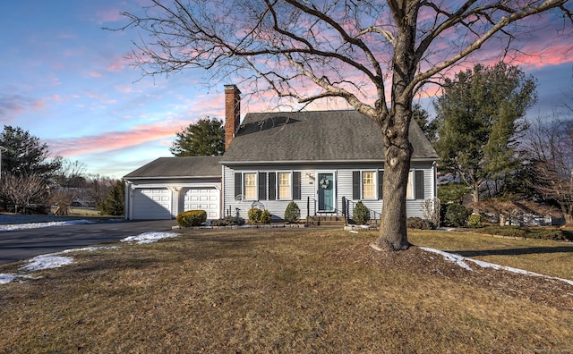 cape cod home with a lawn and a garage