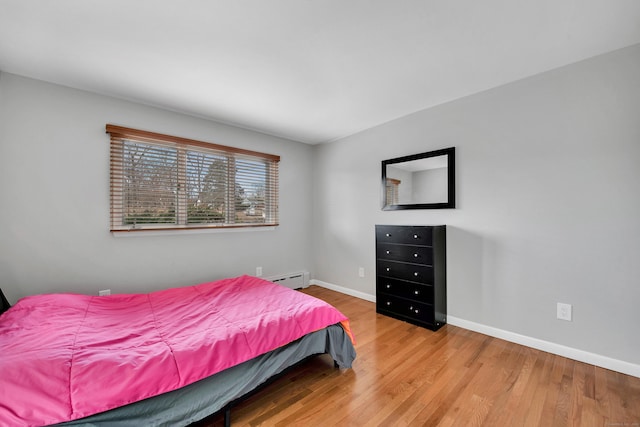 bedroom with wood-type flooring and a baseboard radiator