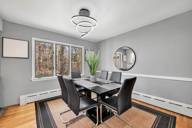 dining area featuring a baseboard radiator and light hardwood / wood-style flooring