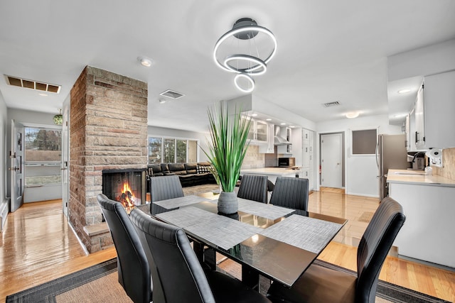 dining room featuring light hardwood / wood-style floors, a stone fireplace, and sink