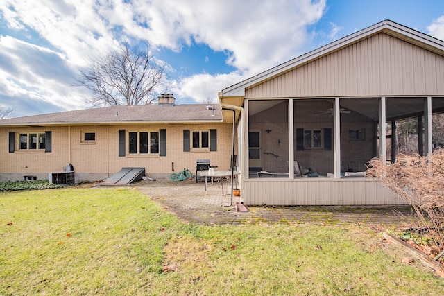 back of house featuring a sunroom, cooling unit, and a yard