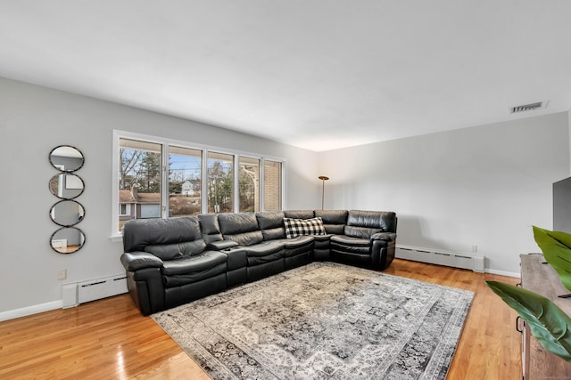 living room featuring light hardwood / wood-style floors and a baseboard heating unit