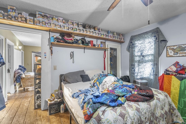 bedroom featuring hardwood / wood-style floors, a textured ceiling, and ceiling fan