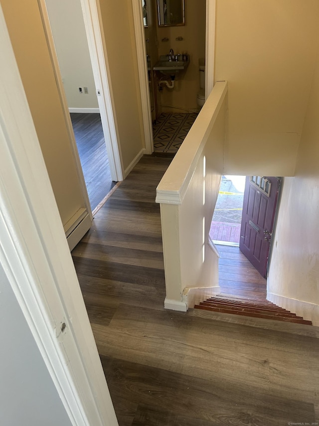 corridor with dark hardwood / wood-style flooring and sink