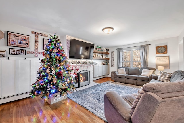 living room featuring a baseboard heating unit and light hardwood / wood-style flooring