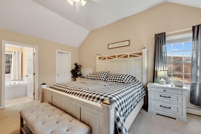 bedroom with light carpet, ceiling fan, ensuite bathroom, and vaulted ceiling