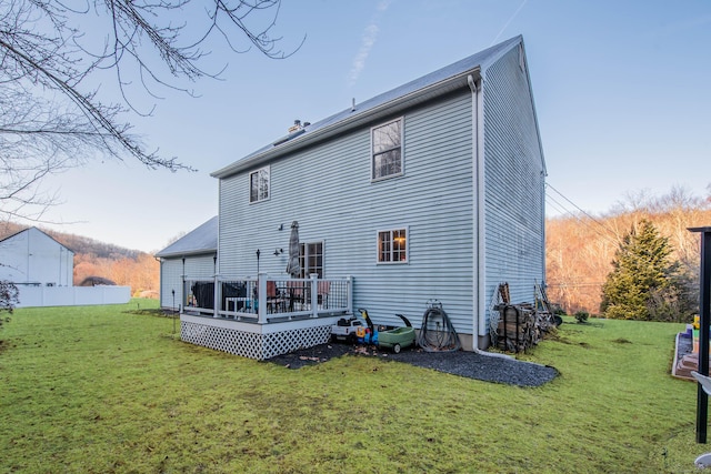 back of property featuring a yard and a wooden deck