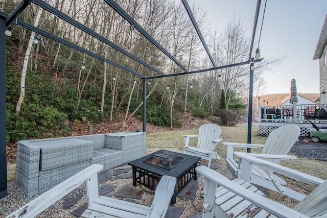 view of patio / terrace with a wooden deck and an outdoor living space with a fire pit