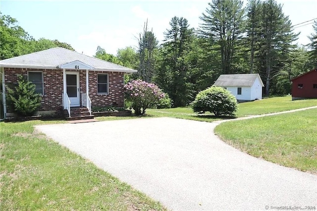 view of front of house featuring an outdoor structure and a front yard