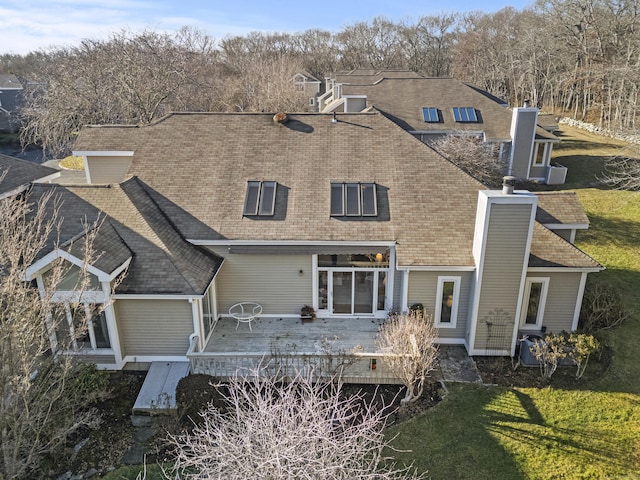 rear view of house featuring a lawn and a deck