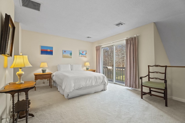 carpeted bedroom featuring a textured ceiling and access to outside