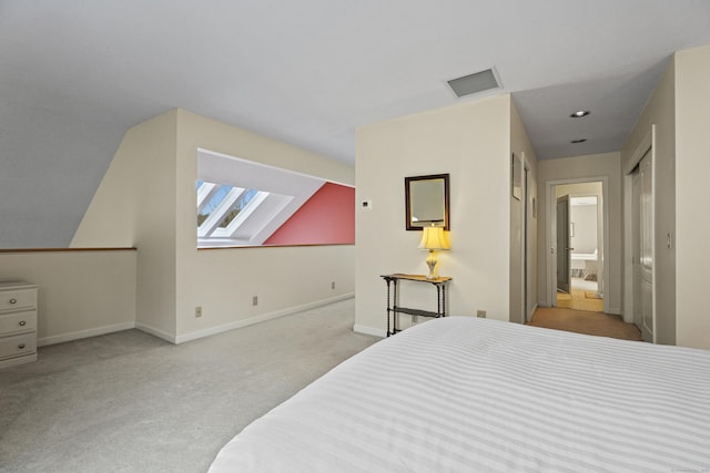 bedroom with light colored carpet and connected bathroom