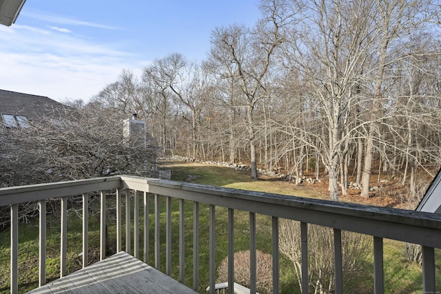 wooden deck featuring a lawn