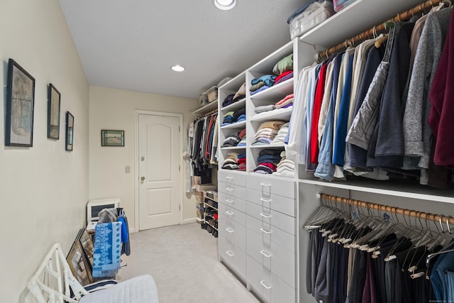 spacious closet featuring light colored carpet