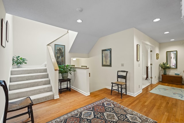 entryway with wood-type flooring and vaulted ceiling