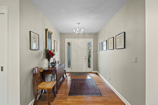 foyer featuring a chandelier, a textured ceiling, and hardwood / wood-style flooring