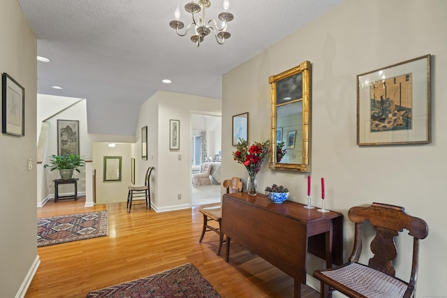 hall featuring a chandelier, a textured ceiling, and hardwood / wood-style flooring