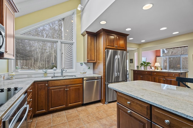 kitchen with light stone counters, sink, plenty of natural light, and appliances with stainless steel finishes