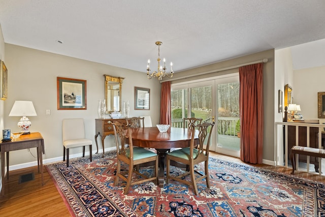 dining room featuring wood-type flooring and a chandelier