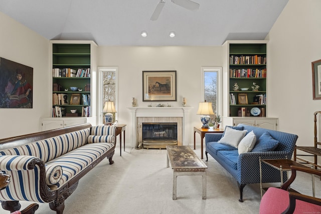 carpeted living room with a fireplace, ceiling fan, and lofted ceiling