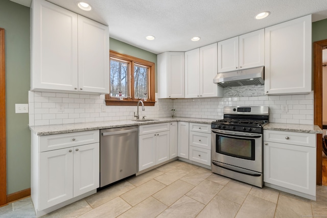 kitchen featuring white cabinetry, appliances with stainless steel finishes, sink, and light stone counters