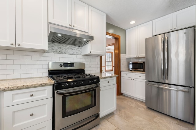 kitchen featuring stainless steel appliances, backsplash, white cabinets, and light stone counters